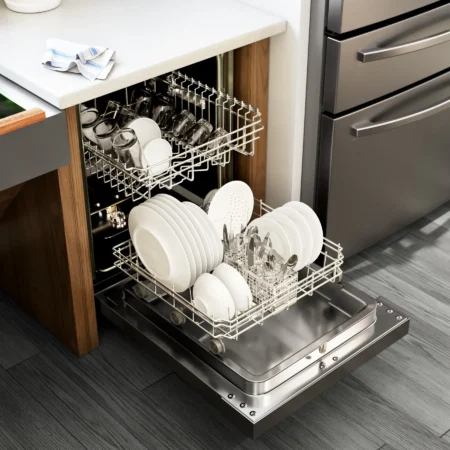 3D render of a dishwasher loaded with dishes in a modern kitchen.