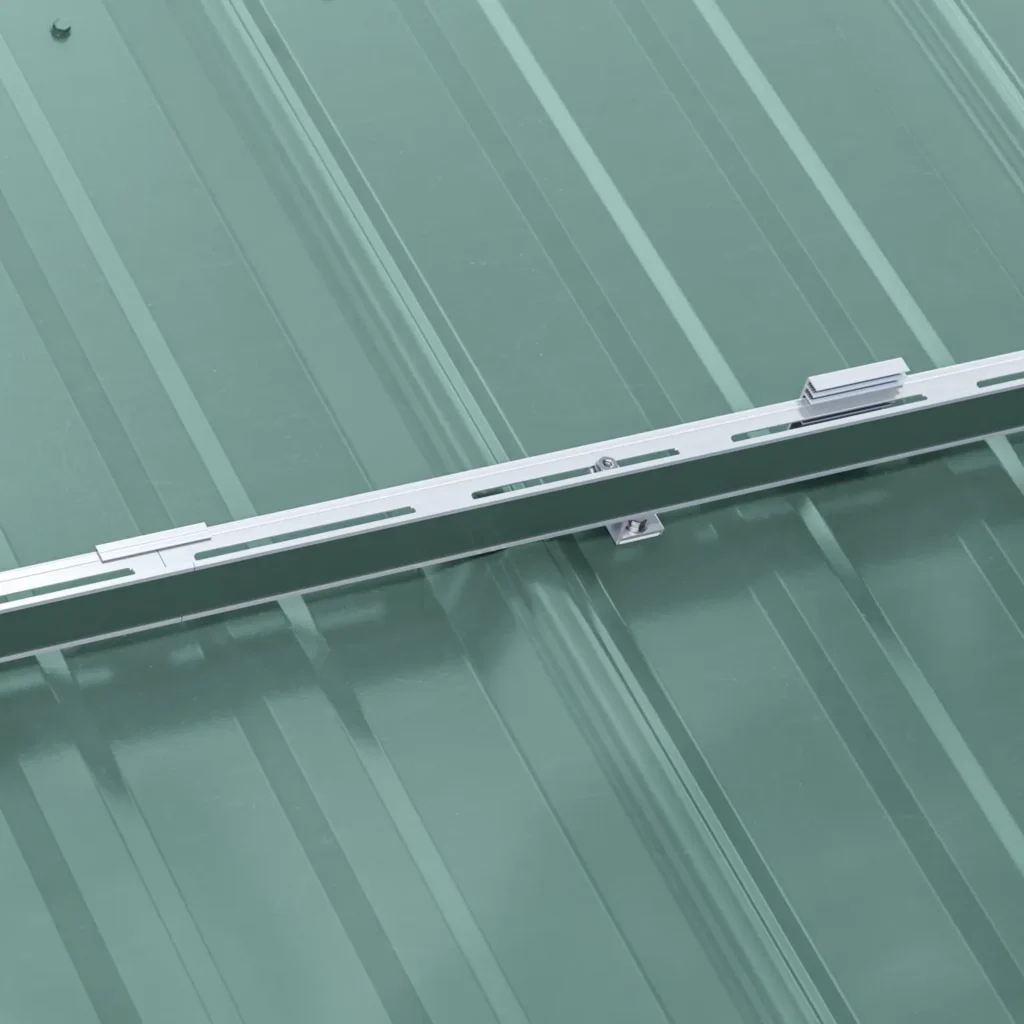 A fastened snow rail system installed on a green metal roof.