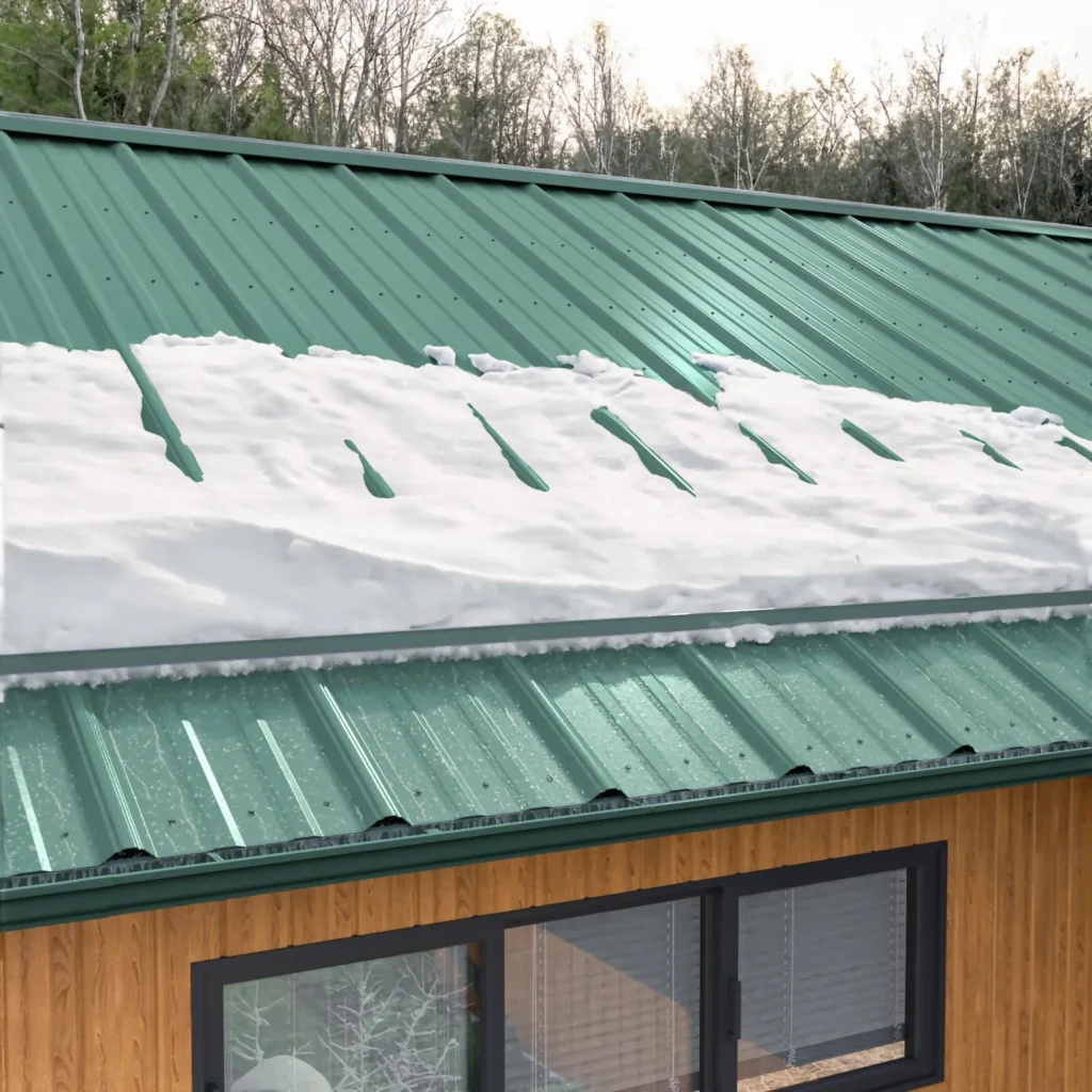 Snow accumulating on a green fastened metal roof.