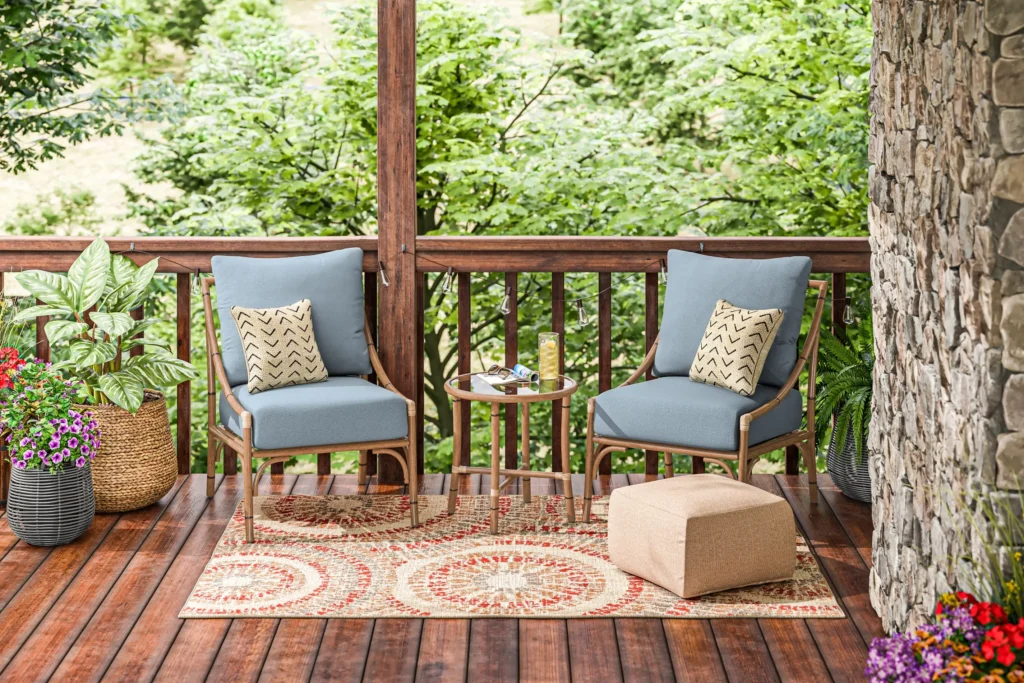 patio furniture 3D rendering of a patio setup with blue-cushioned chairs and a wooden table.