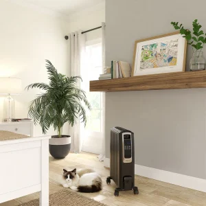 "A digital oil-filled heater stands on the floor next to a relaxed cat in a bright, stylish bedroom, highlighting comfort and efficiency."