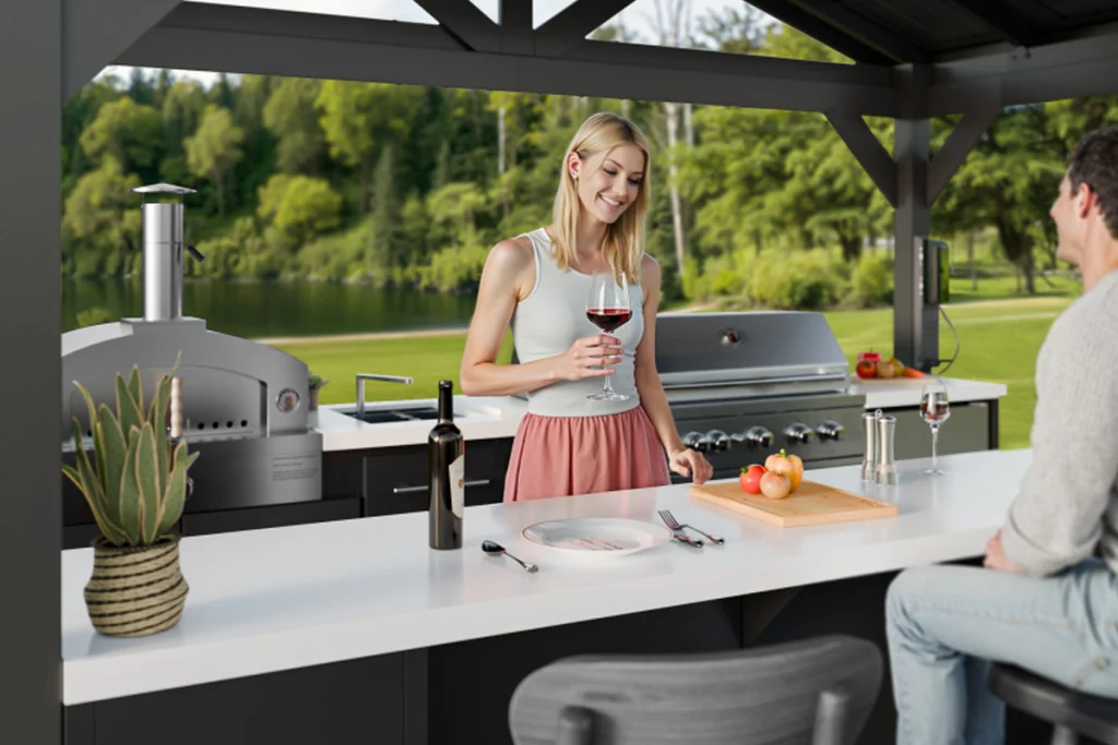 A woman enjoying a glass of red wine in a covered outdoor kitchen area with a grill in the background